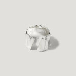 wide silver ring with sculpted geometric pattern on light background
