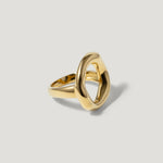 Gold open geometric statement ring on light grey background