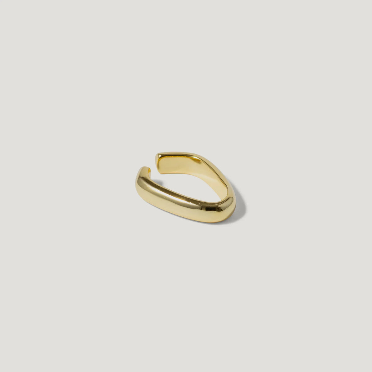 Minimalist gold open ring on white background, modern chunky jewelry design
