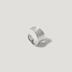 Wide brushed silver statement ring on light background