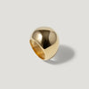 Polished gold dome statement ring on a light grey background