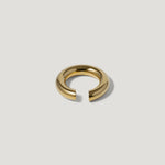 Minimalist gold open band ring on a plain light background