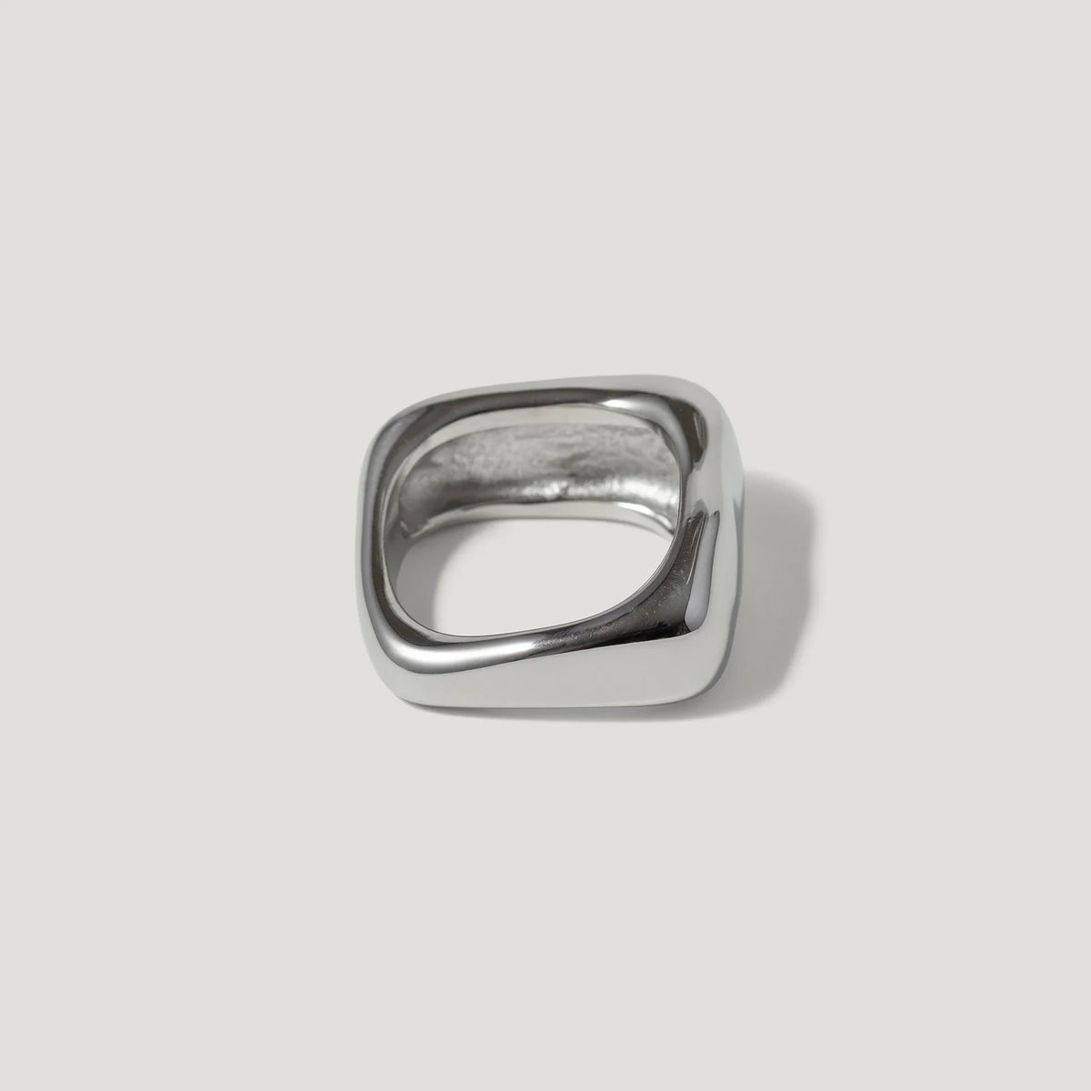 Modern square silver ring with polished finish on plain background