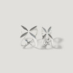 Pair of openwork silver rings with geometric petal design on light background