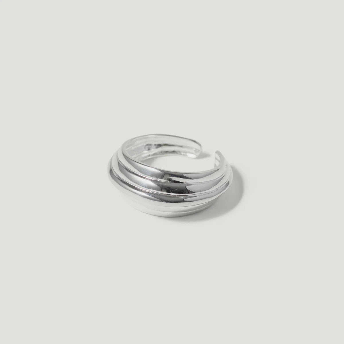 silver layered band ring with open back on white background
