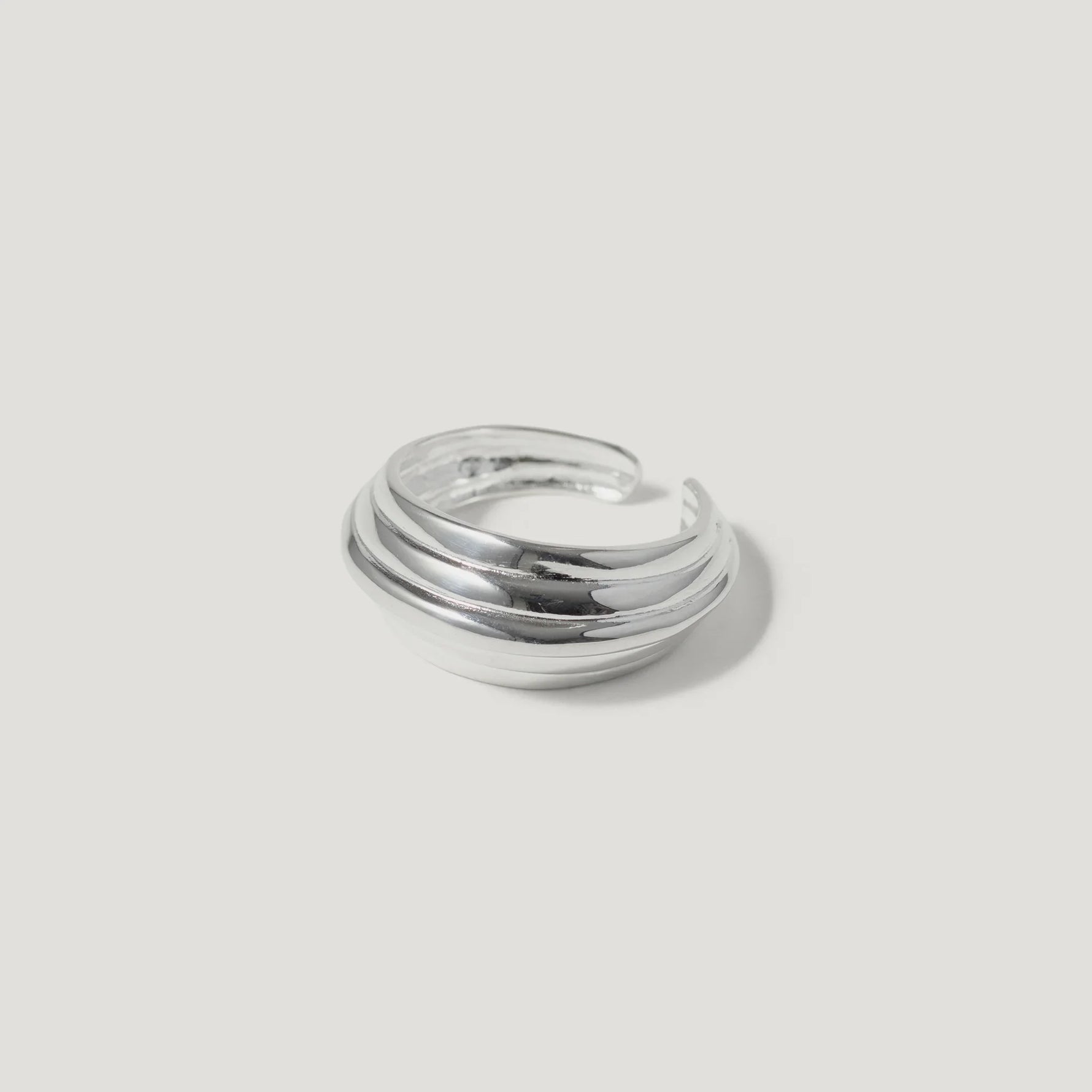 silver layered band ring with open back on white background