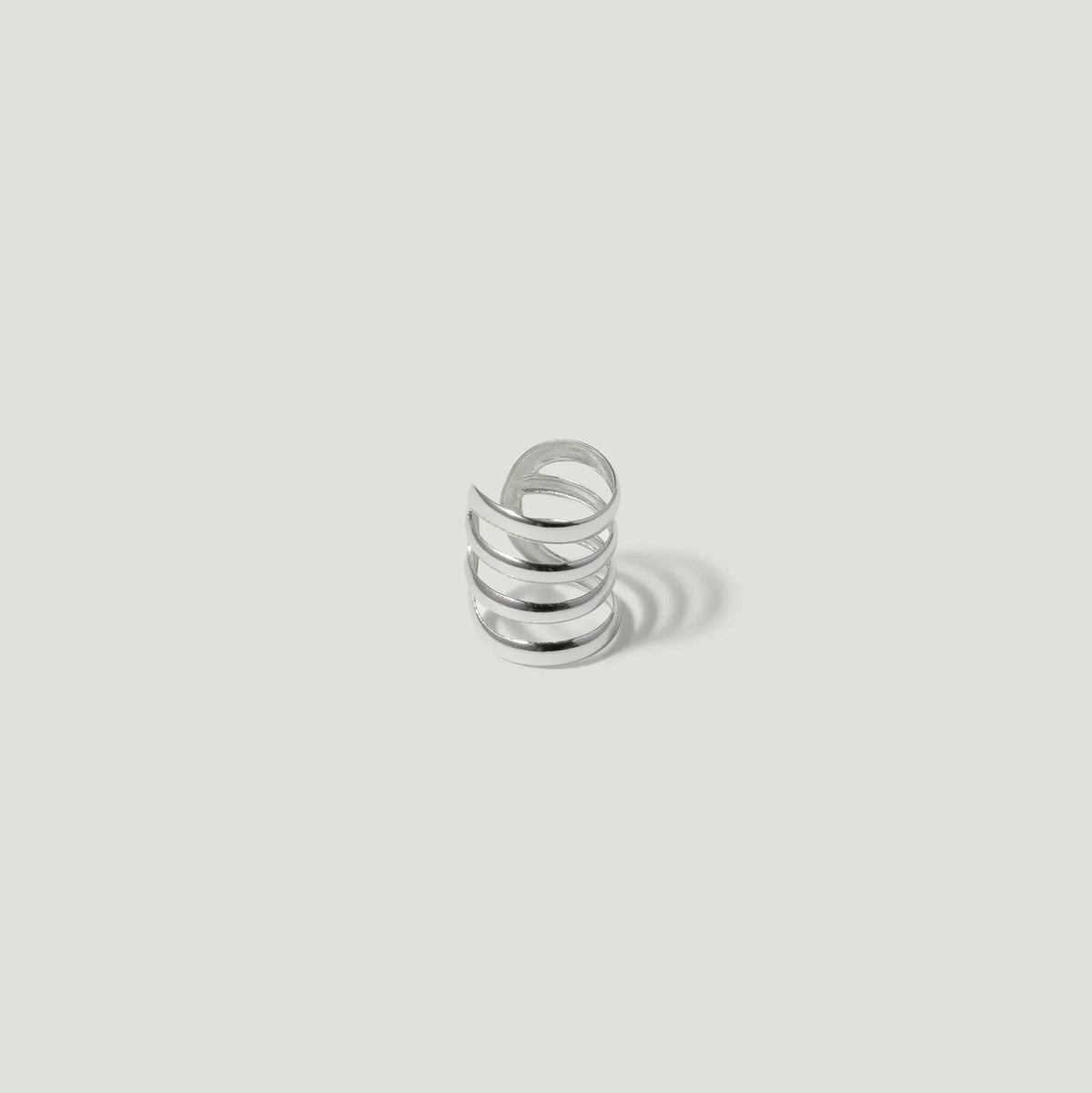 Silver spiral ring with open design on white background, modern minimalist jewelry