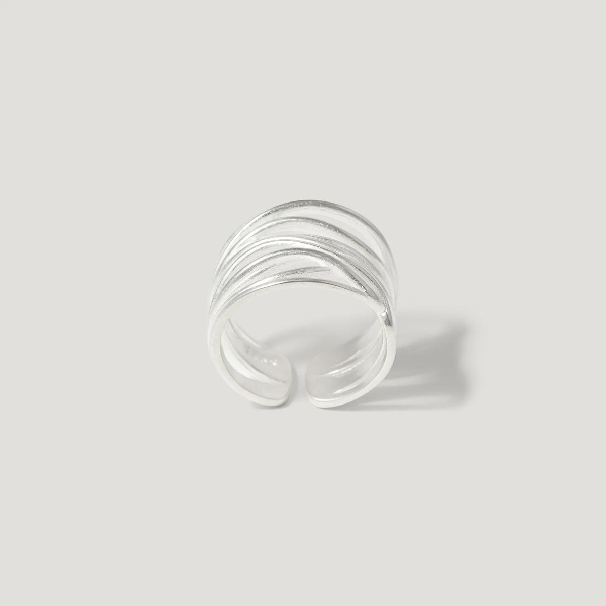 Textured sterling silver open band ring on a light background