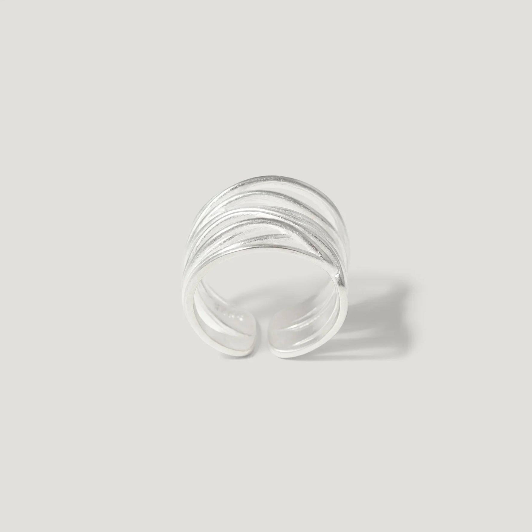 Textured sterling silver open band ring on a light background