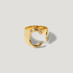 Gold adjustable ring in the shape of the letter C on a light background