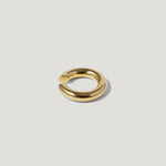 Minimalist gold open ring with smooth, polished finish on a light background