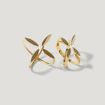 Gold openwork rings with abstract petal shapes on a light background