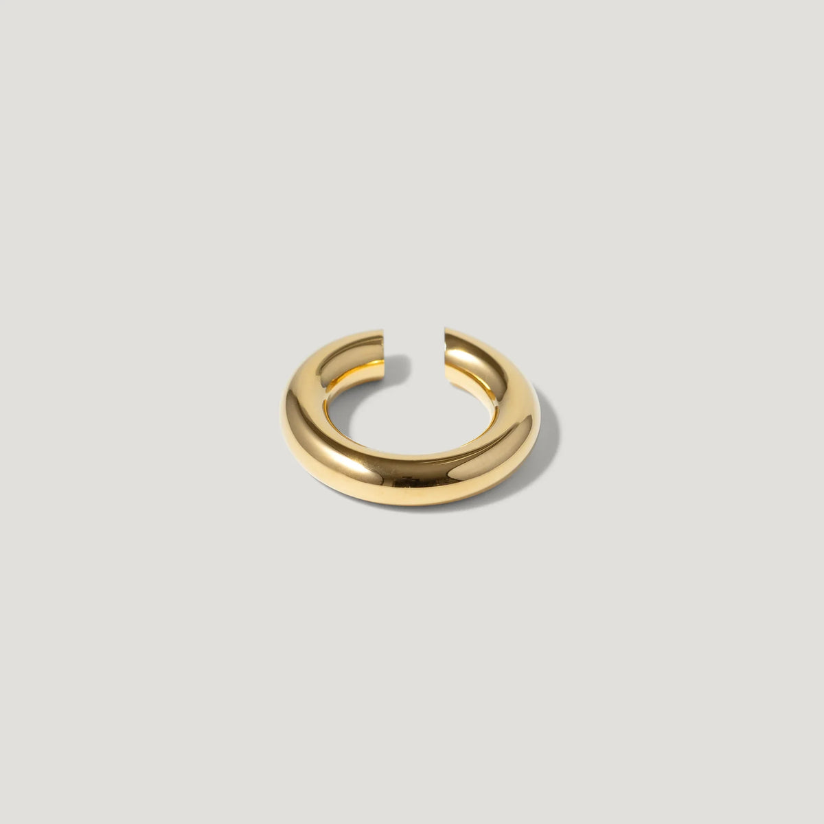 Minimalist gold chunky open hoop ring on light background