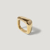 Modern chunky gold ring with smooth, organic shape on light background