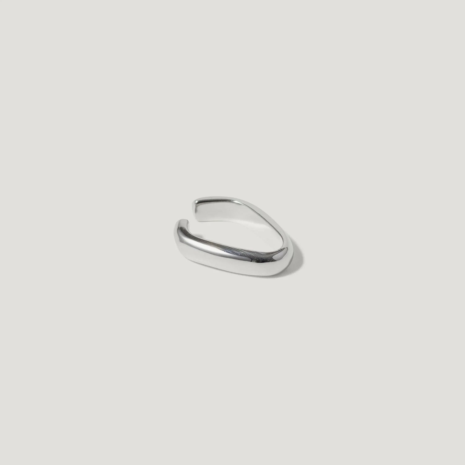 Minimalist silver open ring with smooth, modern design on white background