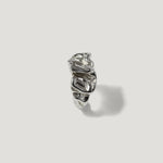 Sculptural silver ring with organic, textured design on a plain light background