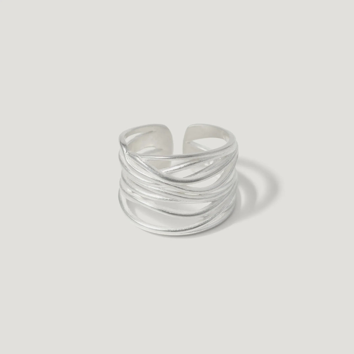 Sterling silver open band ring with layered, textured wire design on white background
