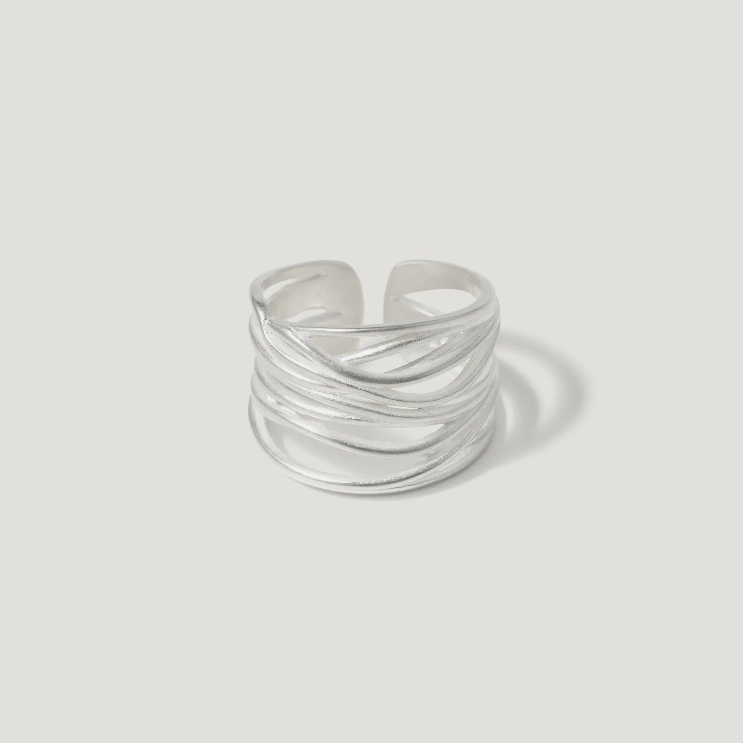 Sterling silver open band ring with layered, textured wire design on white background