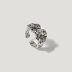 Silver sculpted open ring with organic, textured design on plain background