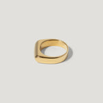 Minimalist gold square ring with smooth finish on a light background