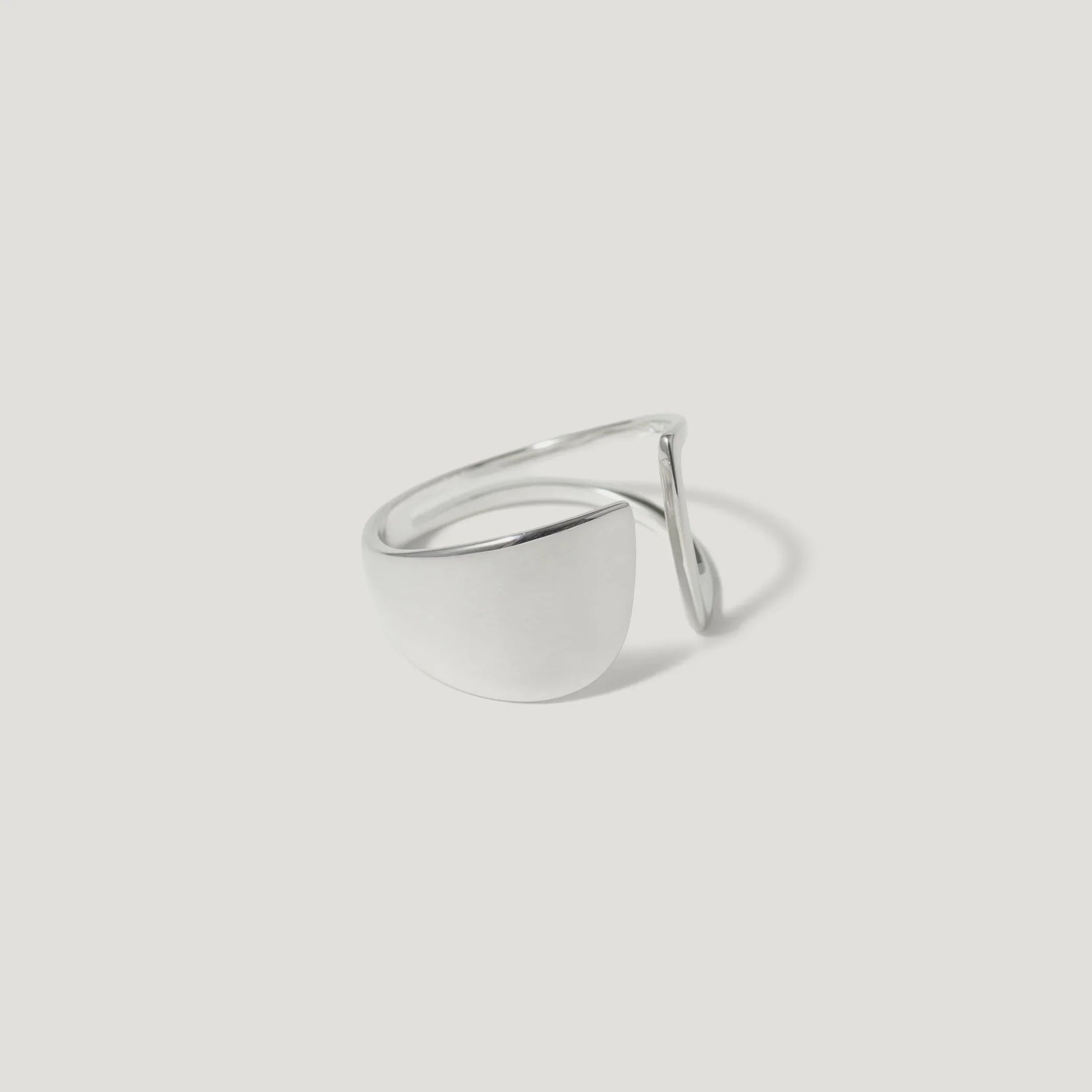 Minimalist silver open ring with geometric design on white background