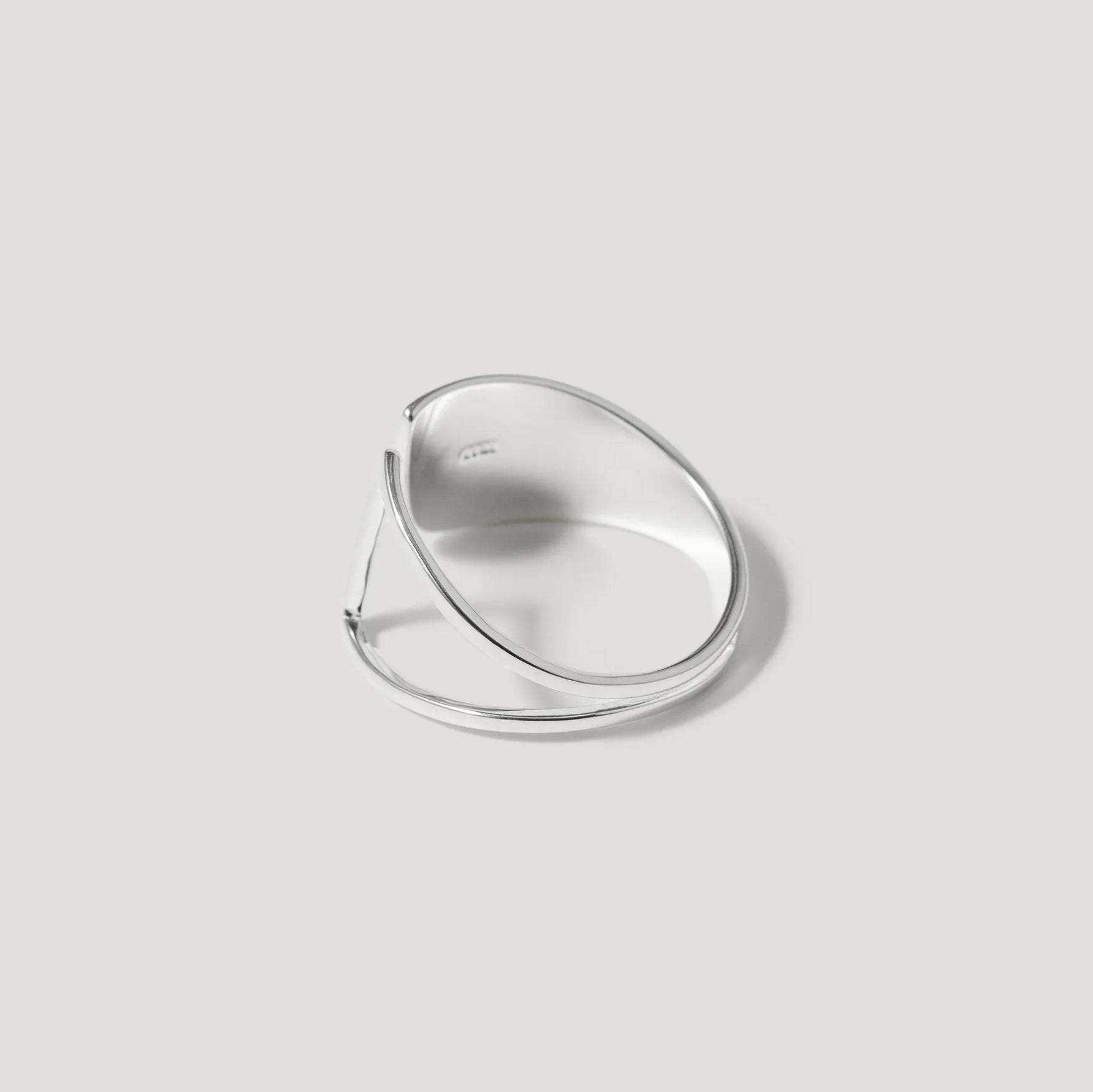 Modern silver open ring with minimalist geometric design on a neutral background