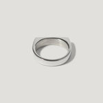 Minimalist silver signet ring with flat top on white background