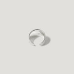 Minimalist open silver ring with smooth finish on a light neutral background