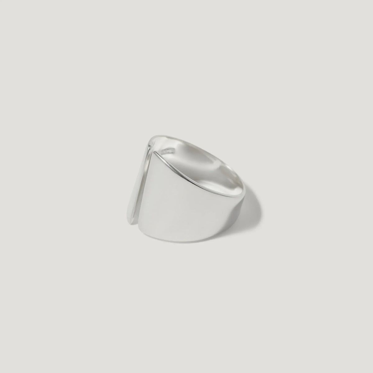 Modern wide sterling silver ring with sculptural, asymmetric design on white background