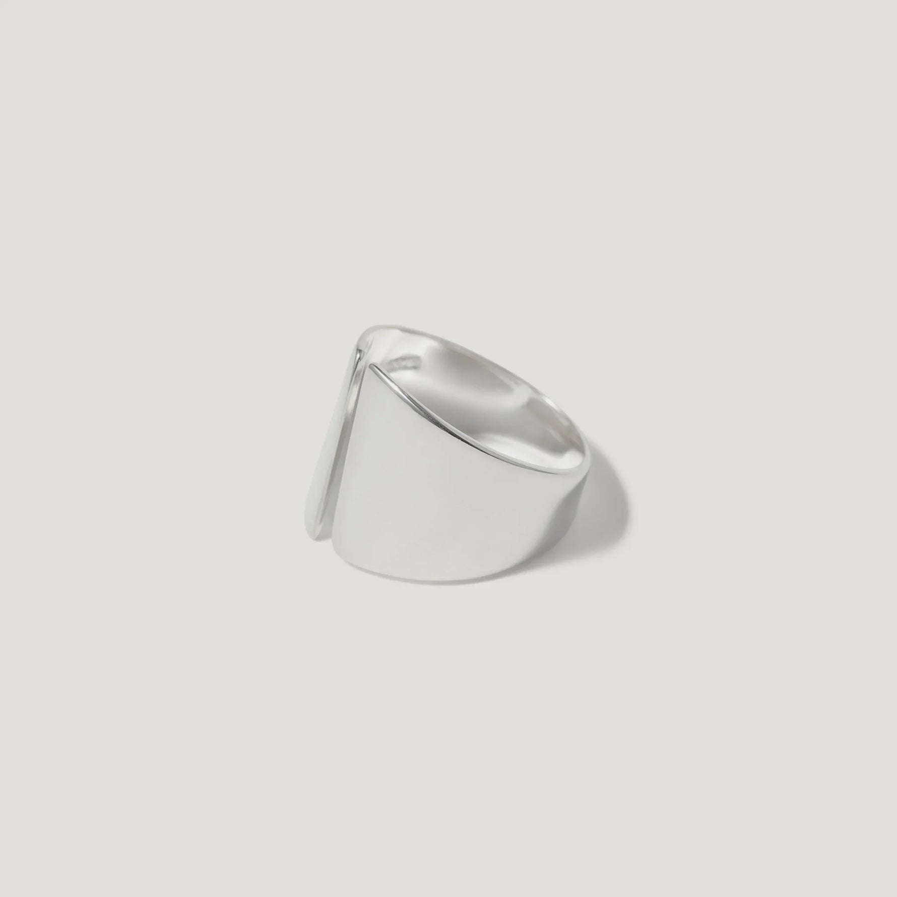 Modern wide sterling silver ring with sculptural, asymmetric design on white background