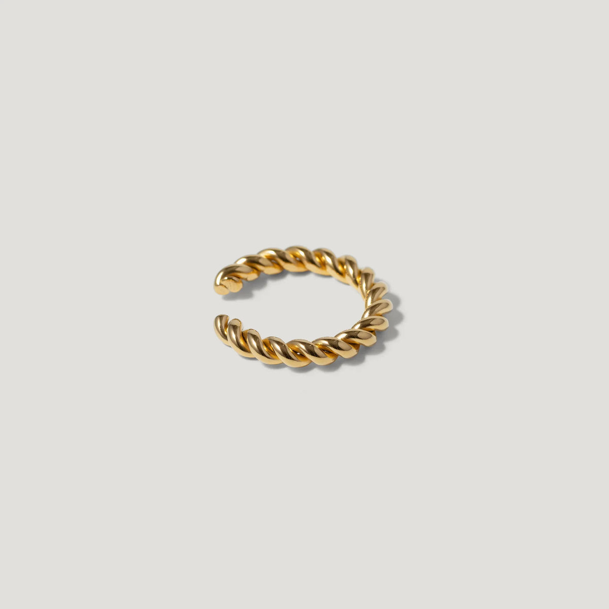 Gold twisted rope ring with open band on white background