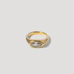 Gold signet ring with marquise-cut clear gemstone on a plain light background