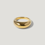 Minimalist gold dome ring with polished finish on a light background
