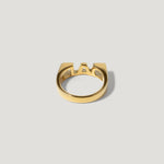 Modern gold ring with geometric cutout design on a light background
