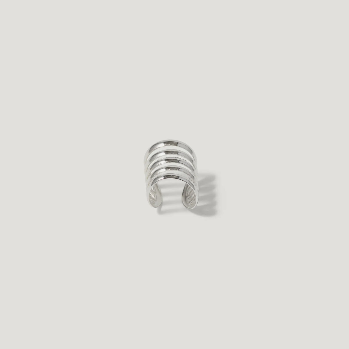 Silver multi-band ear cuff jewelry on white background