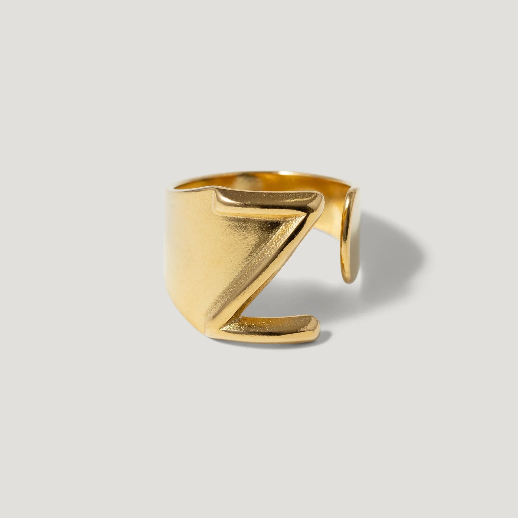 Gold adjustable ring with bold Z design on light background