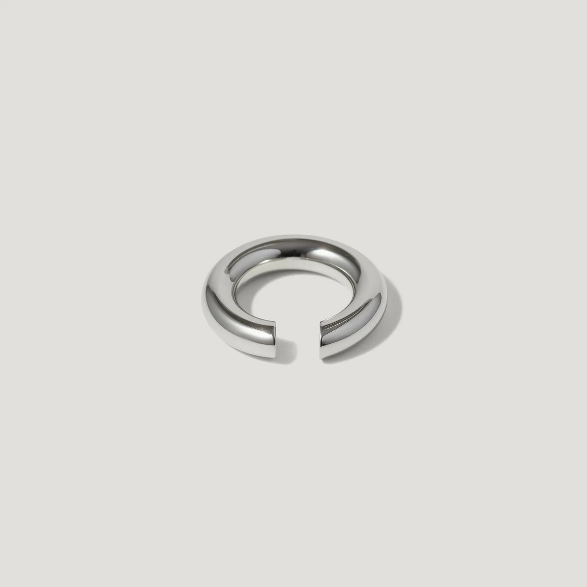Minimalist silver open ring with polished finish on a plain white background