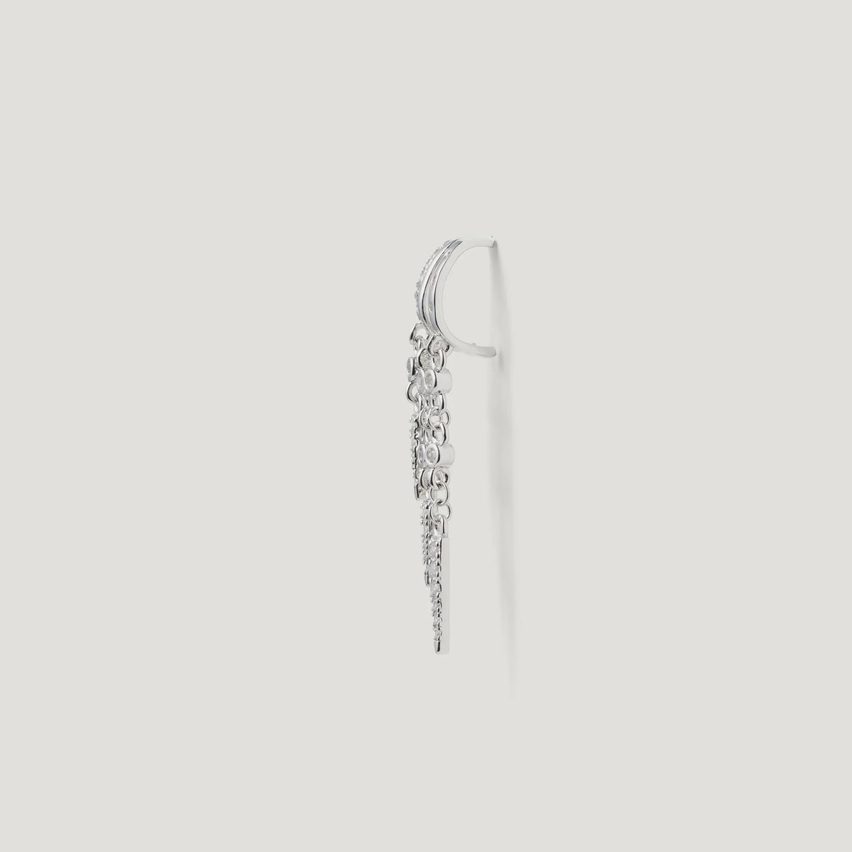 Side view of a silver drop earring with multiple small round and textured charms