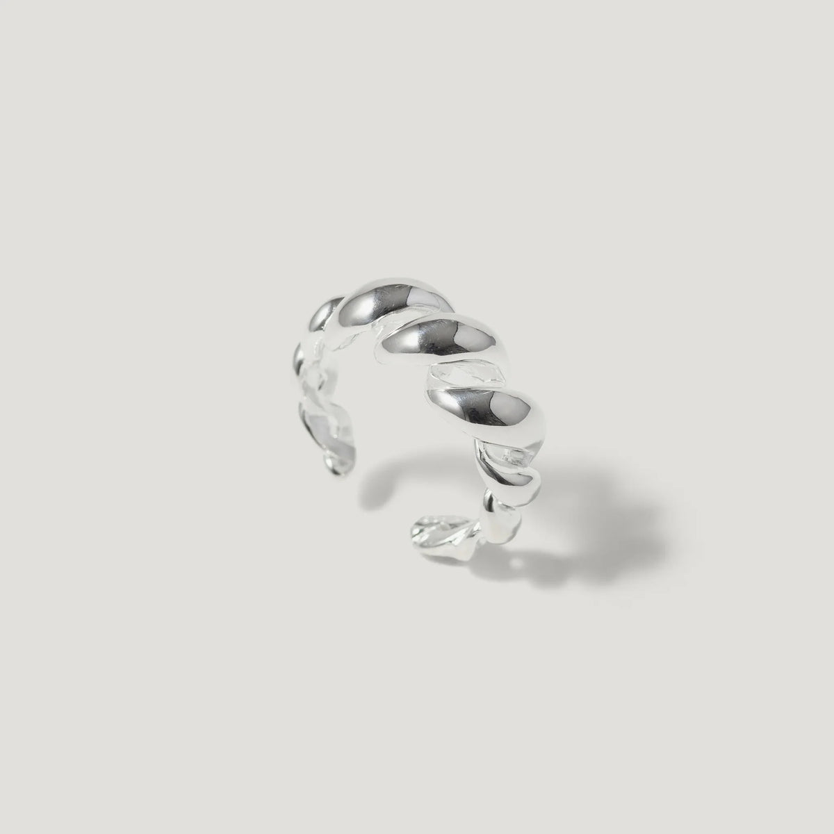 Sterling silver twisted open band ring on a light background