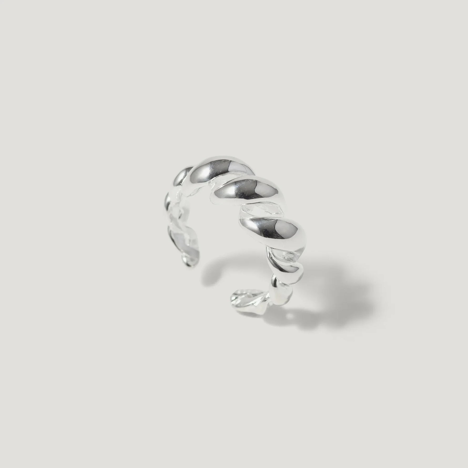 Sterling silver twisted open band ring on a light background