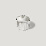 Modern silver ring with sculpted, wavy texture on plain light background