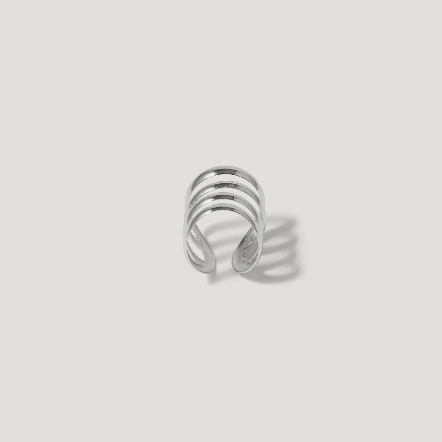 Minimalist silver ear cuff with three parallel bands on a white background