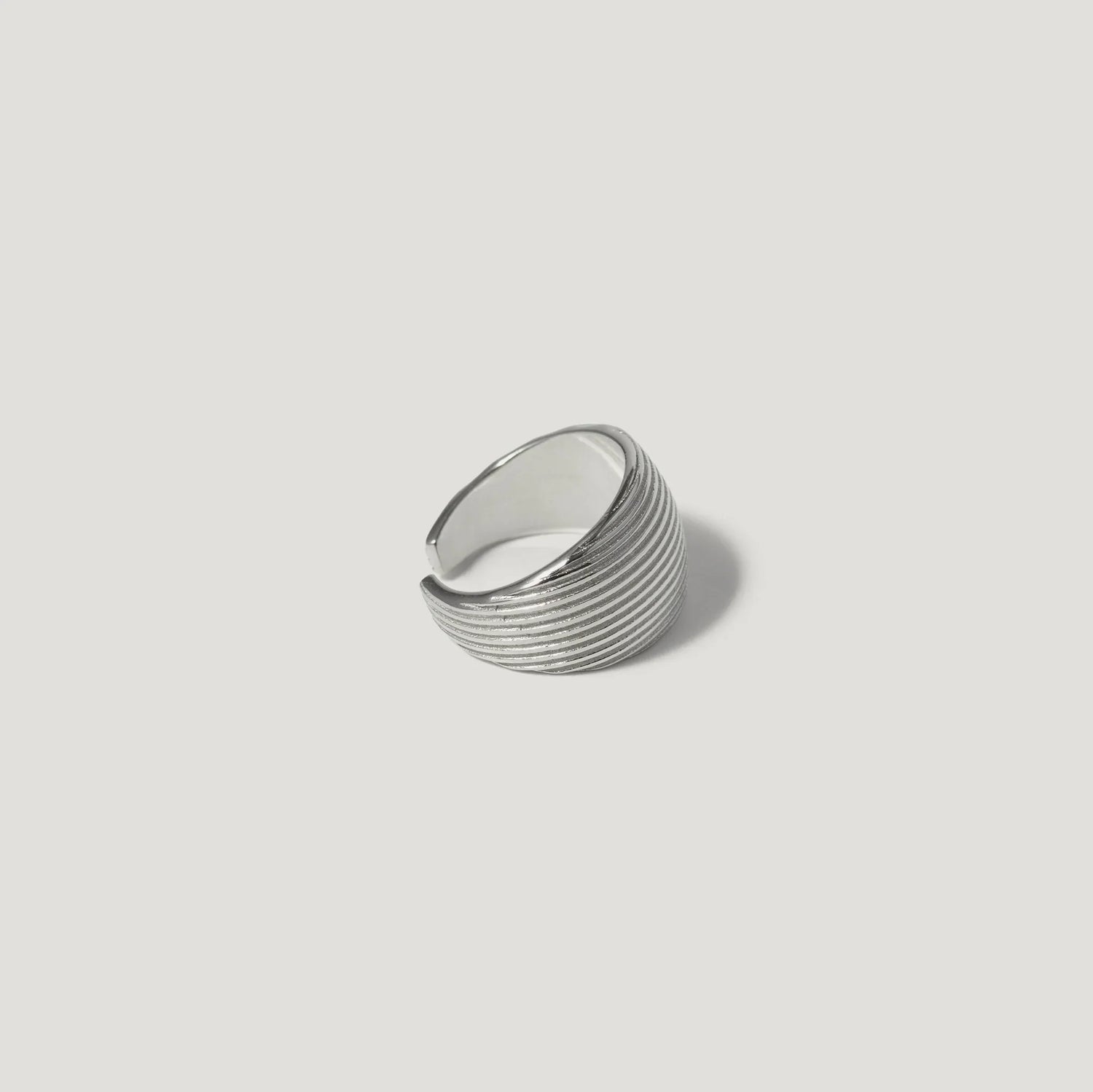 Sterling silver textured band ring with grooved design on white background