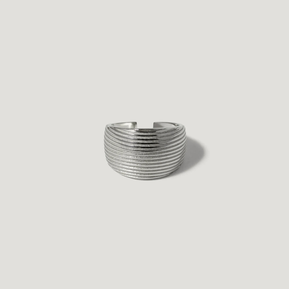 Textured silver band ring with horizontal grooves on a plain white background