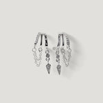 Silver hoop earrings with dangling chains and geometric diamond charms on white background