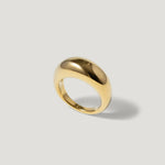 polished gold dome ring minimalist jewelry on light background