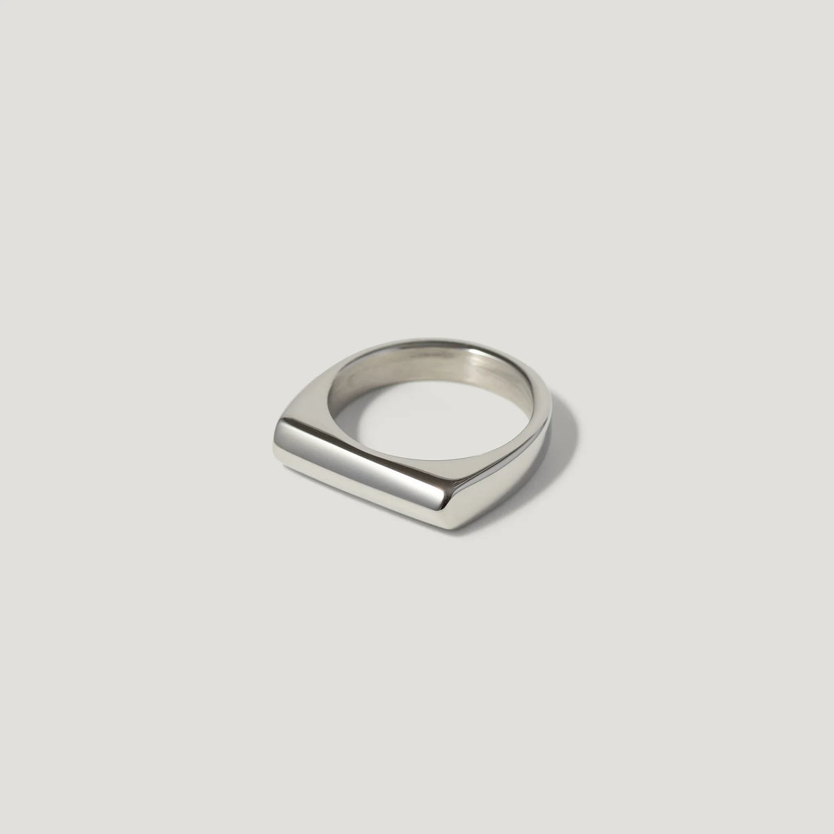 Minimalist silver bar ring with polished finish on a plain light background