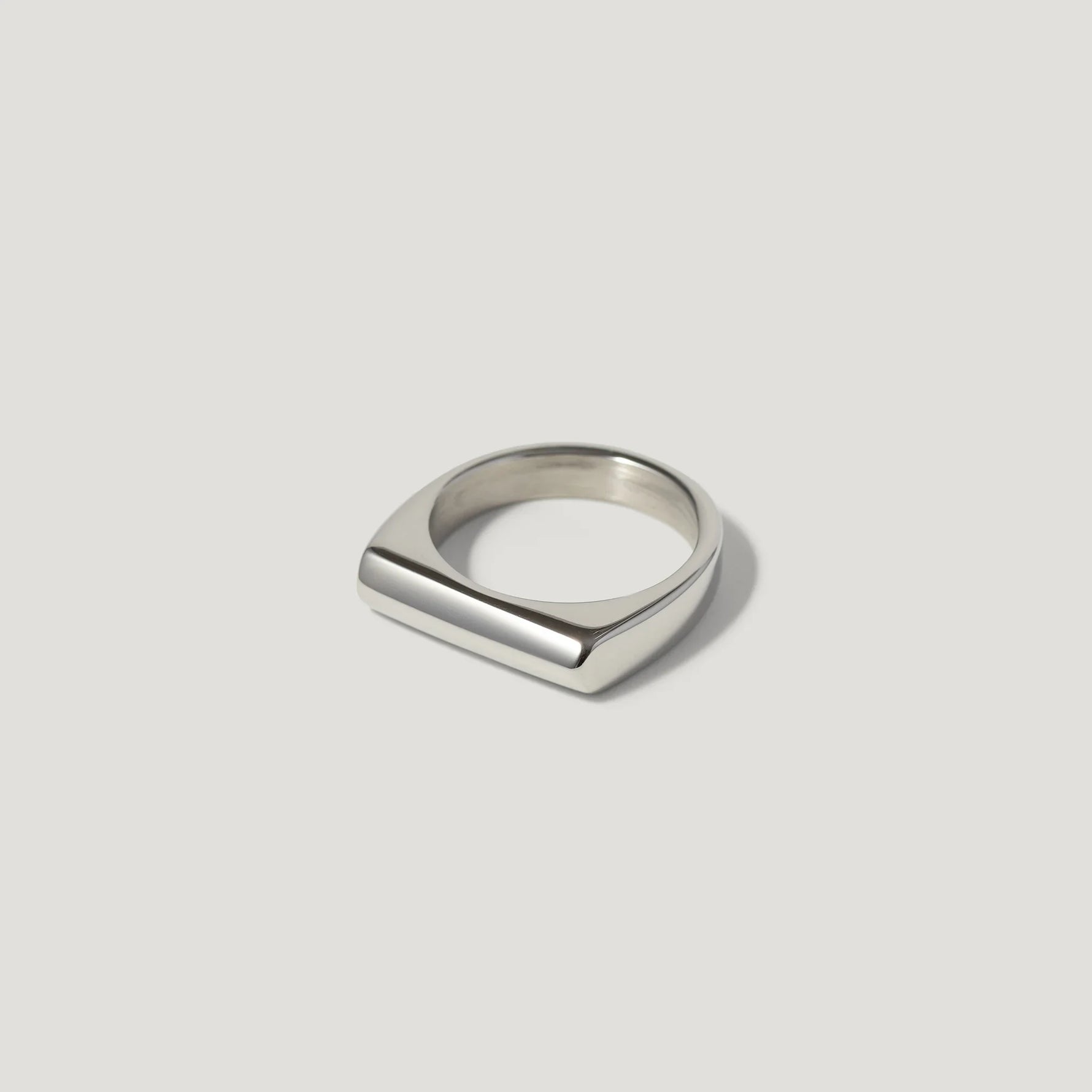 Minimalist silver bar ring with polished finish on a plain light background