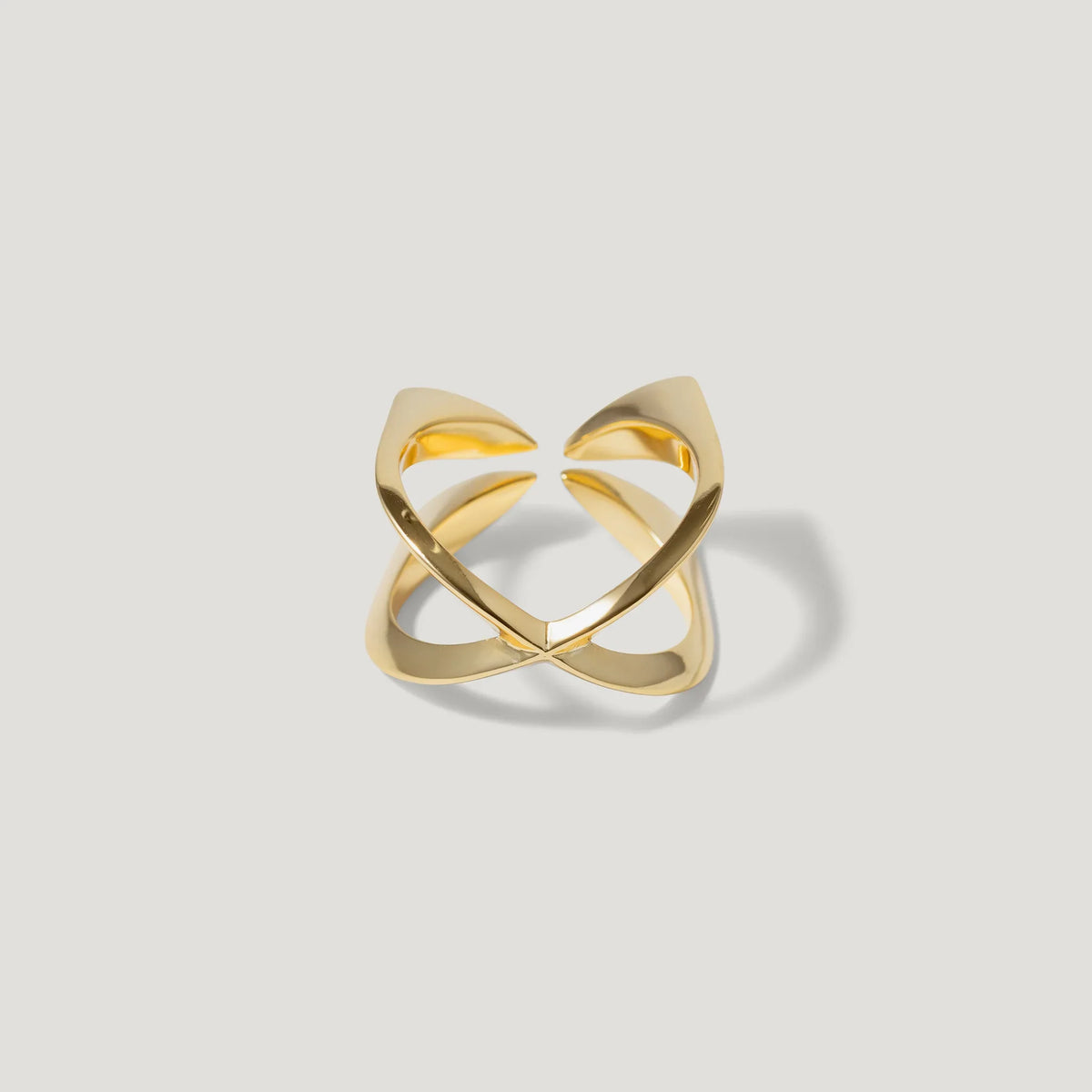 Modern open gold ring with geometric design on white background