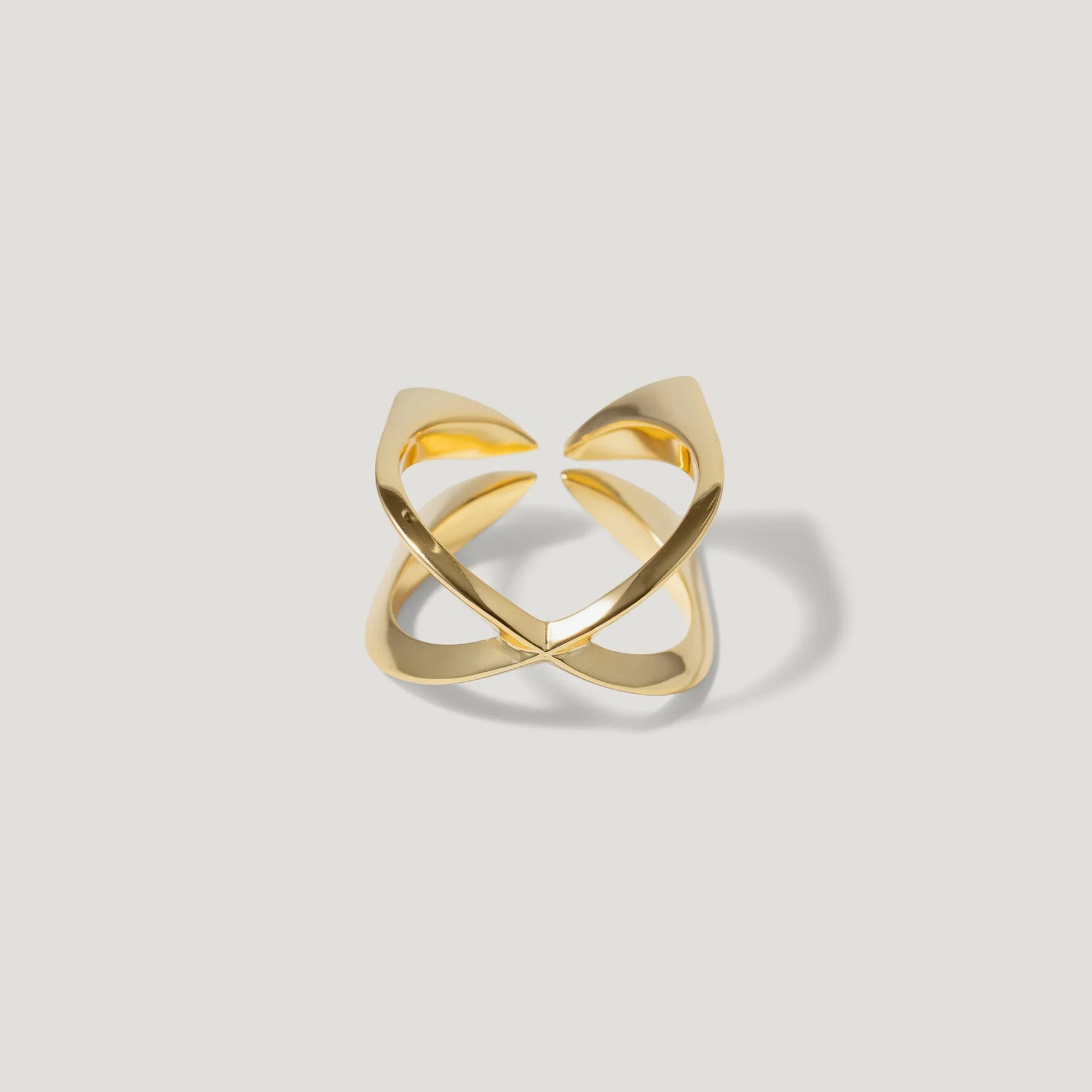 Modern open gold ring with geometric design on white background